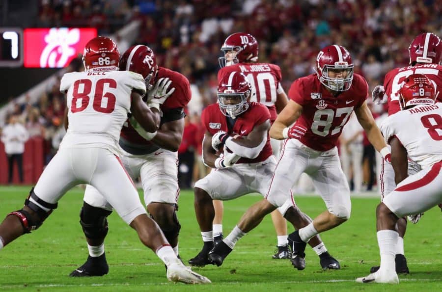 Quarterback Mac Jones hands off to running back Najee Harris, who cuts up the middle in a 2019 Arkansas matchup.
