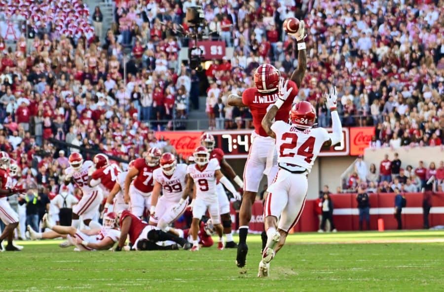 Alabama wide receiver Jameson Williams jumps over an Arkansas defender to catch a pass from Bryce Young on Saturday, Nov. 21. 